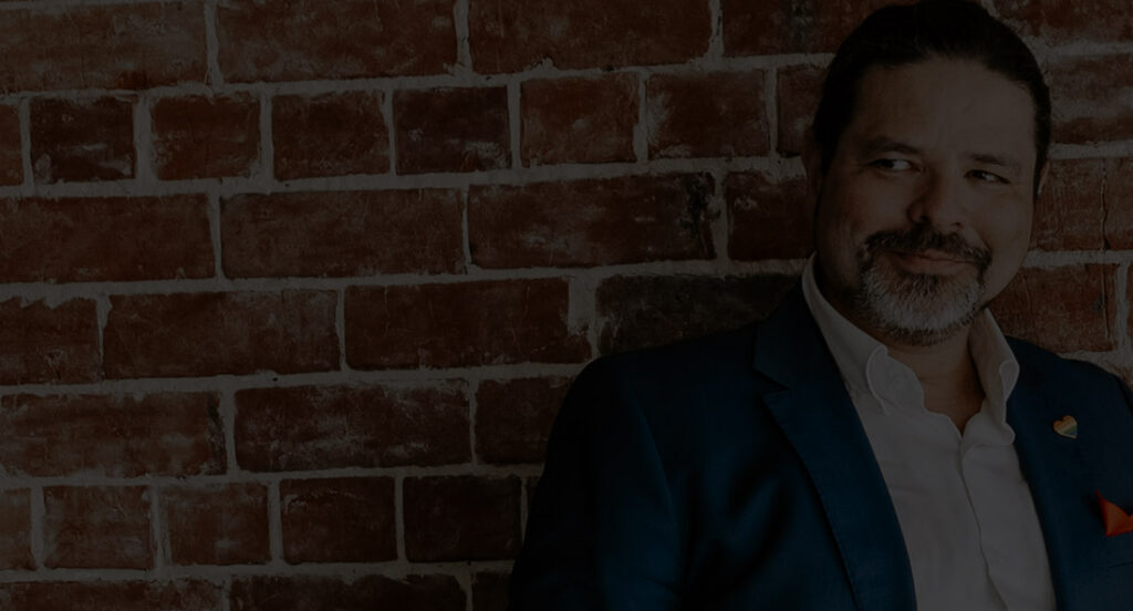 Eddie looking menacingly sexy while leaning on a brick wall.